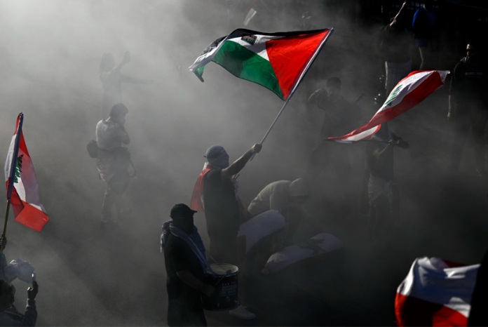Gus Baha: Palestina tak Bisa Terenyahkan Demonstran pro-Palestina mengibarkan bendera dalam unjuk rasa di Ottawa, Ontario, Sabtu, 5 Oktober 2024.